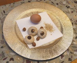 Leckere Makronen mit einem Ei auf einem goldenen Teller