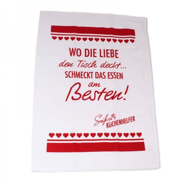 Weißes Geschirrtuch mit roter Schrift "Wo die Liebe den Tisch deckt... schmeckt das Essen am Besten!" und Logo Seifert's Küchenhelfer.